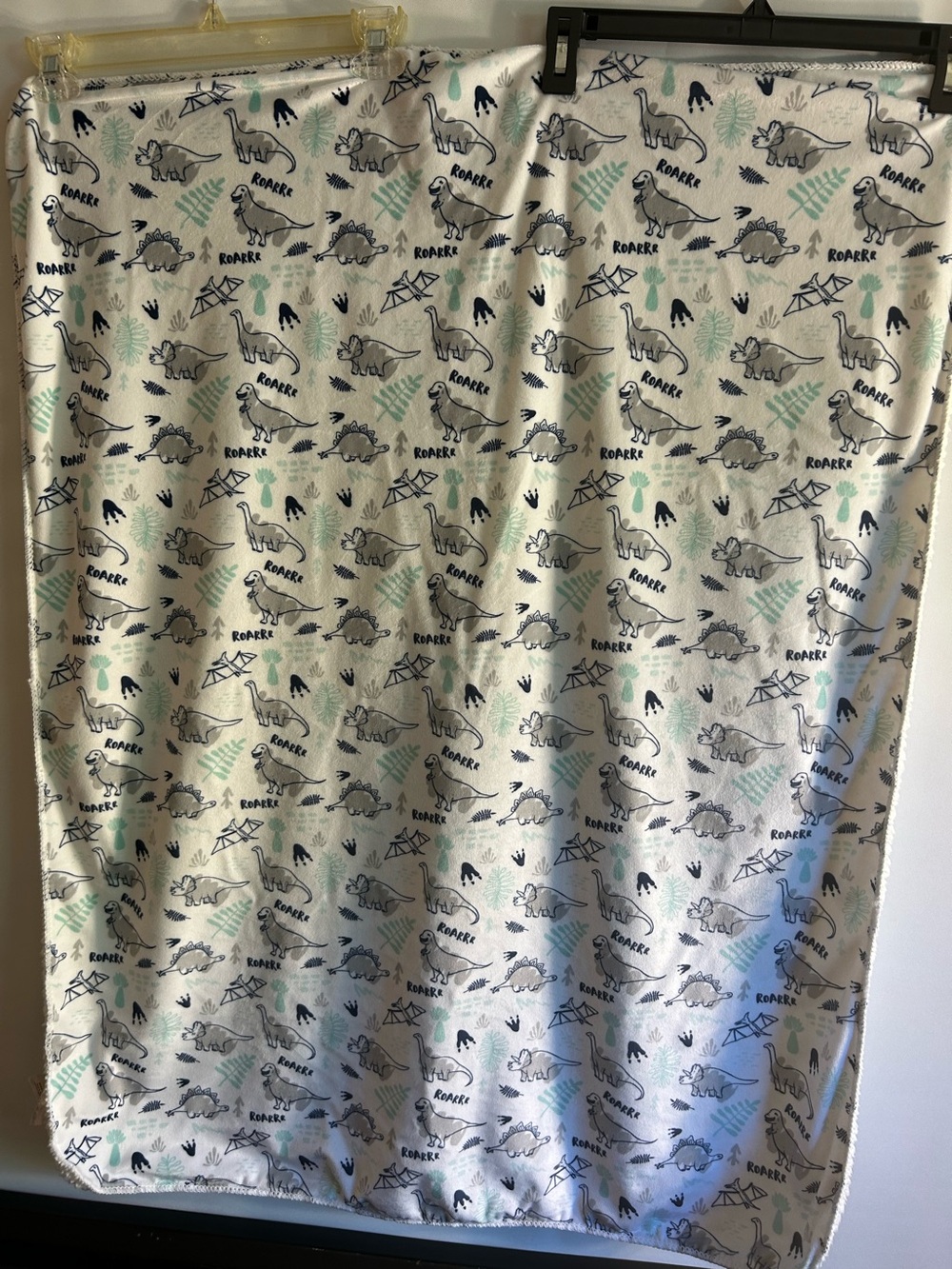 ROARrr WHITE FLEECE BLANKET FEATURES A PATTERN OF GREY & GREEN DINOSAURS